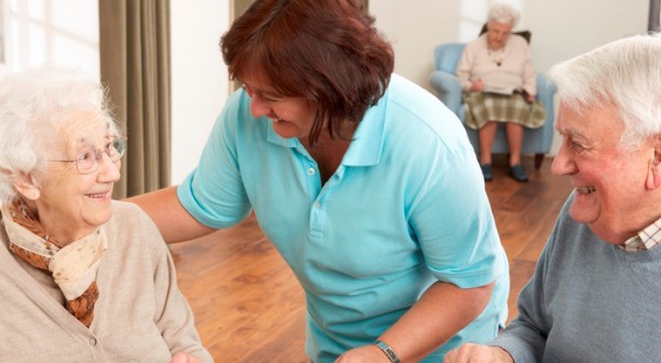 Senior Couple Being Served Meal By Carer